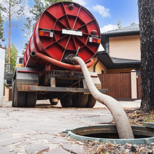 Sewer pumping machine. Septic truck. Pipe in the drainage pit. Pumping out sewage from a septic tank. Septic tank service